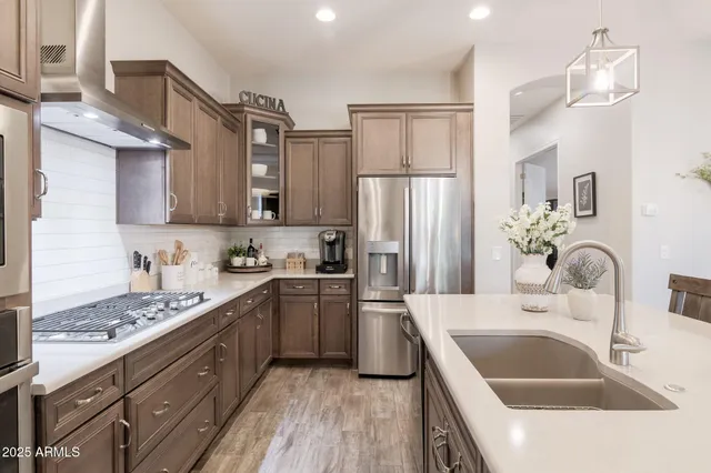a kitchen with stainless steel appliances granite countertop a sink stove and refrigerator