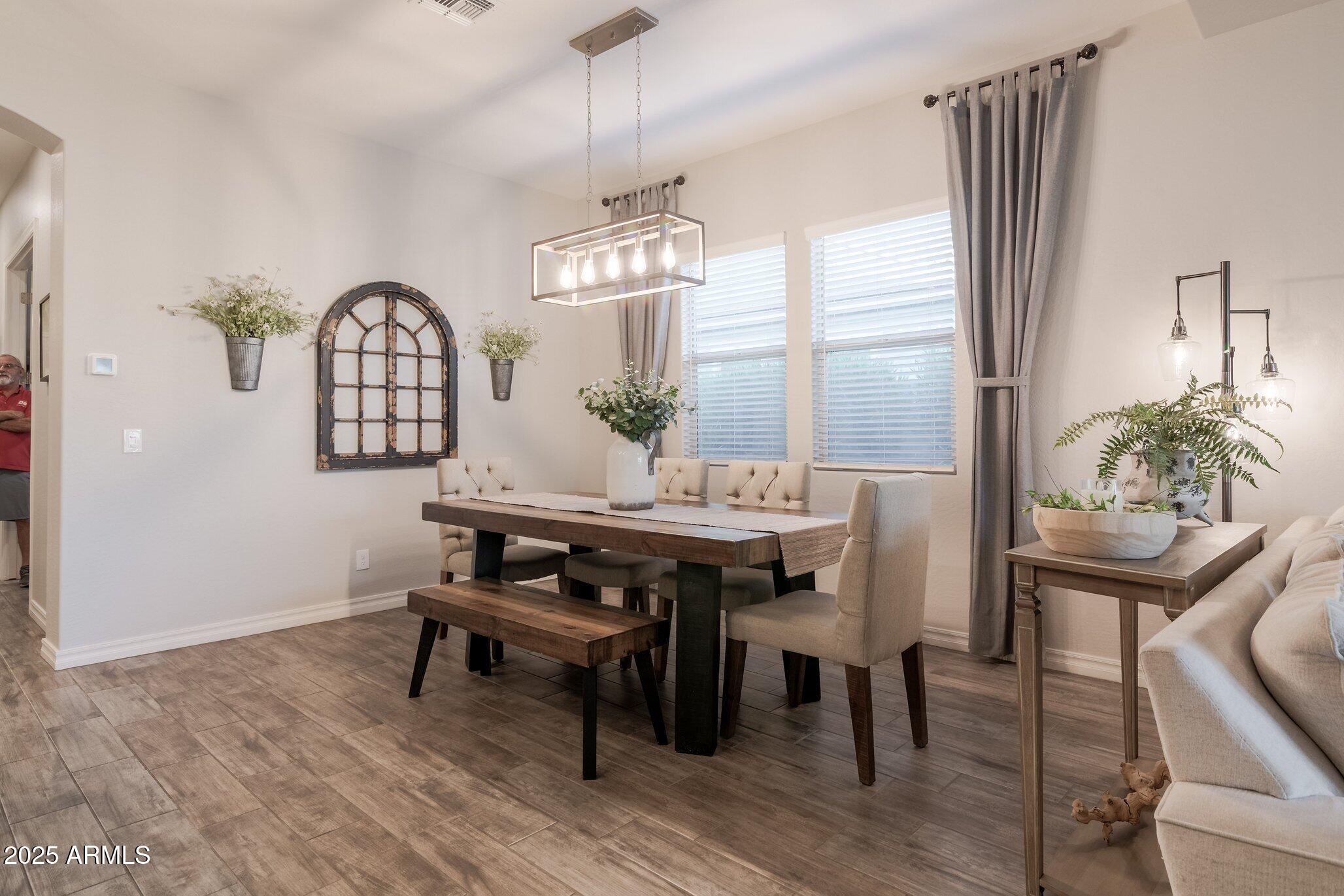 3437 East Appaloosa Road Gilbert, AZ 85296 - Photo 16 of 47 a view of a dining room with furniture window and wooden floor