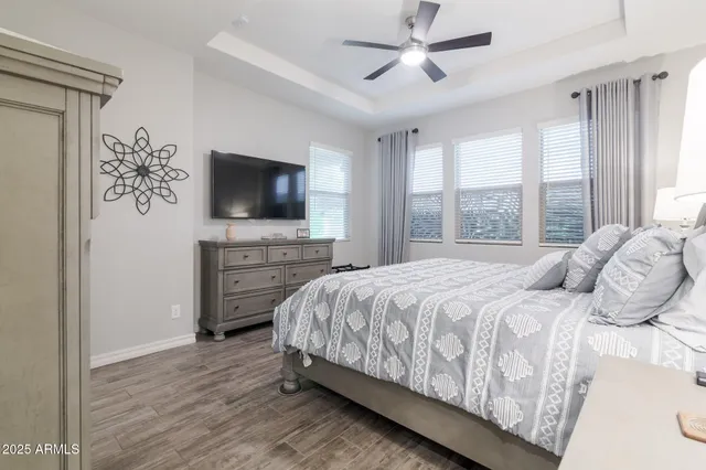 a bedroom with a bed television and a window