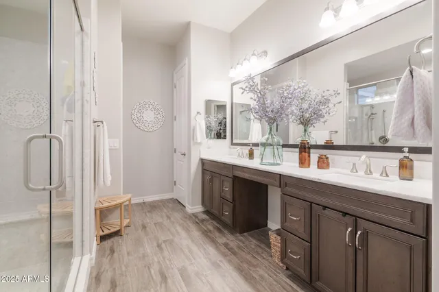 a spacious bathroom with a double vanity sink a mirror and a shower