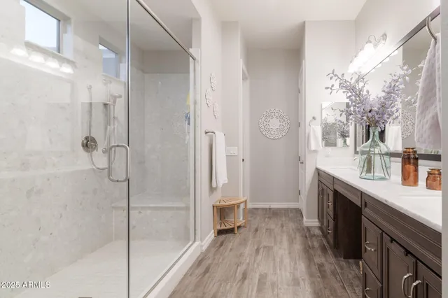 a spacious bathroom with a granite countertop shower a sink and a mirror