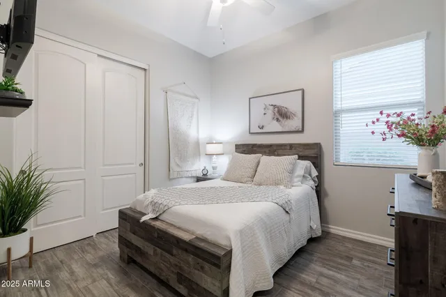 a bedroom with a bed and a potted plant on the dresser