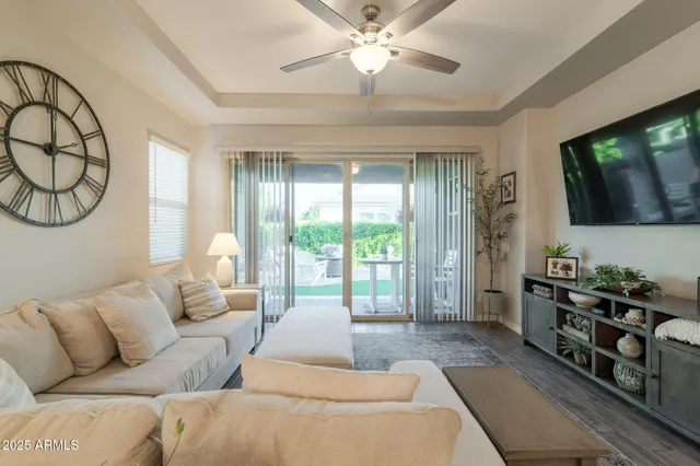 a living room with furniture a flat screen tv and a large window