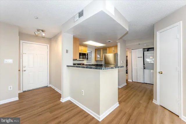 a view of kitchen with stainless steel appliances refrigerator stove microwave and cabinets