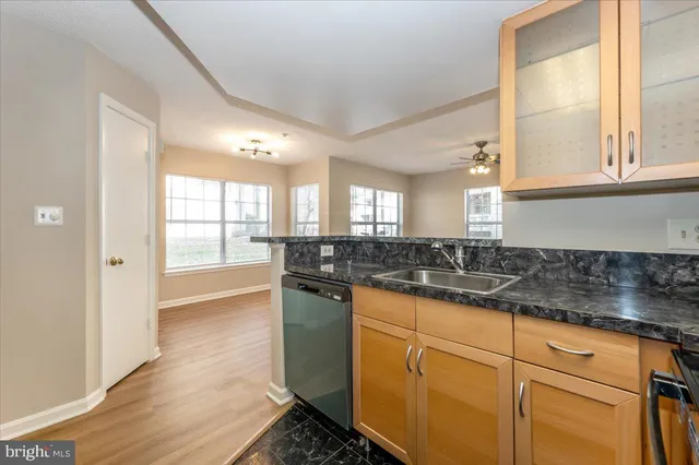a kitchen with granite countertop a stove and white cabinets