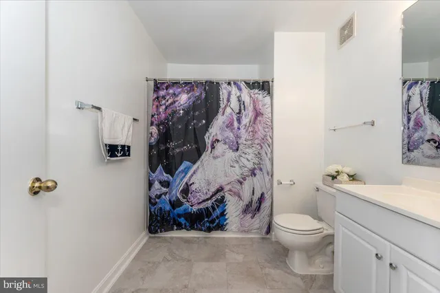a bathroom with a toilet and a shower curtain