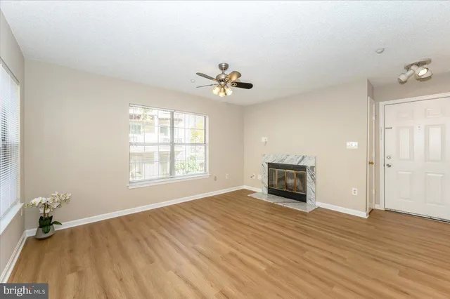 a view of a livingroom with a fireplace a chandelier and wooden floor