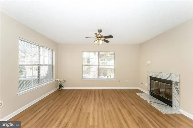 a view of an empty room with a fireplace and a window