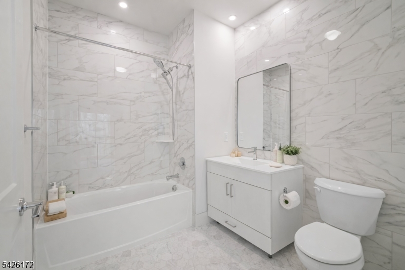 434 Springfield Avenue, Unit 146 Berkeley Heights, NJ 07922 - Photo 13 of 32 a bathroom with a toilet a sink a mirror a bathtub and shower
