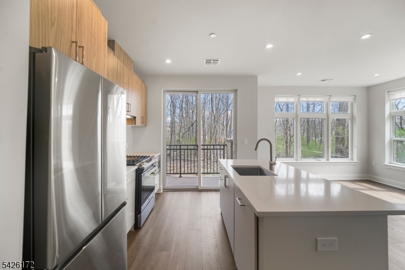 434 Springfield Avenue, Unit 146 Berkeley Heights, NJ 07922 - Photo 22 of 32 a kitchen with refrigerator a sink and cabinets