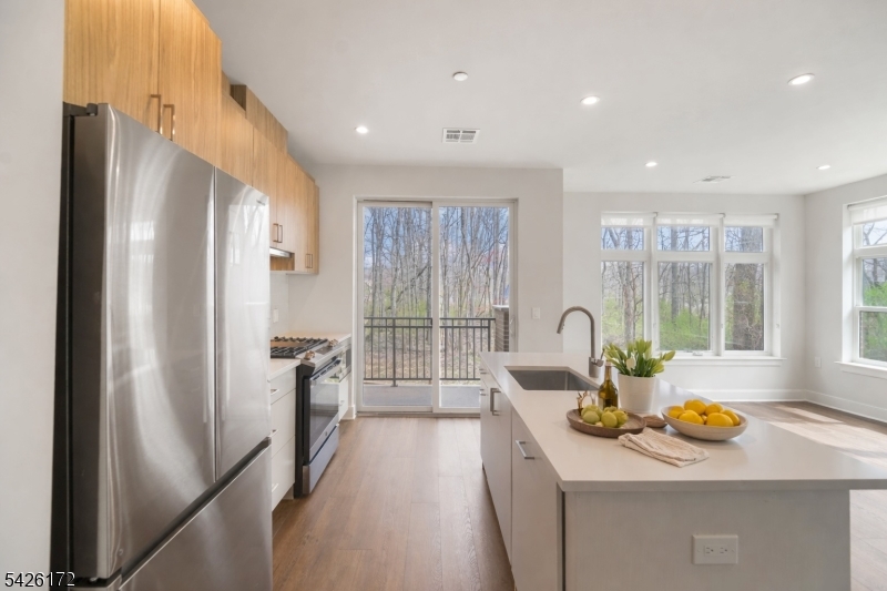 434 Springfield Avenue, Unit 146 Berkeley Heights, NJ 07922 - Photo 4 of 32 a kitchen with refrigerator cabinets and wooden floor