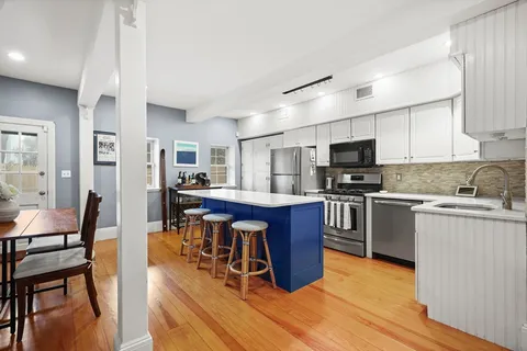 a kitchen with stainless steel appliances wooden floors and wooden cabinets