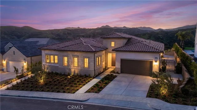 a front view of a house with a yard and mountain view