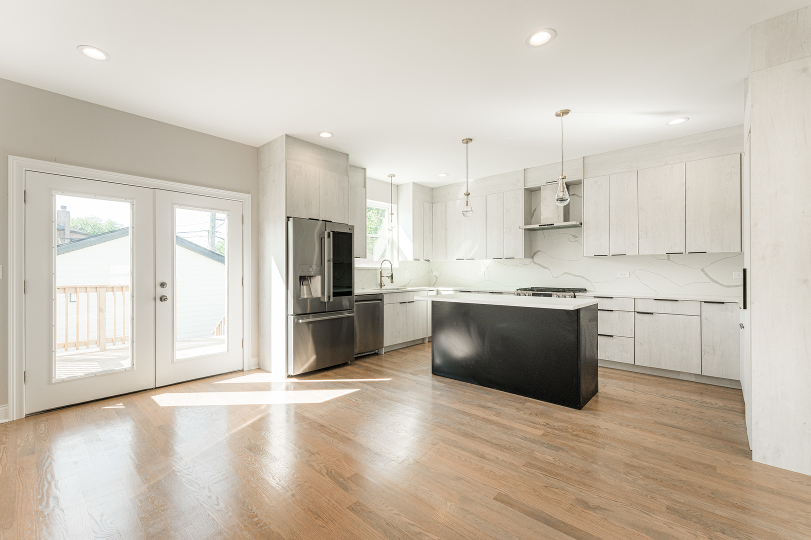 8121 W Forest Chicago, IL 60634 - Photo 7 of 44 a large kitchen with stainless steel appliances kitchen island granite countertop a stove a sink a refrigerator and white cabinets with wooden floor