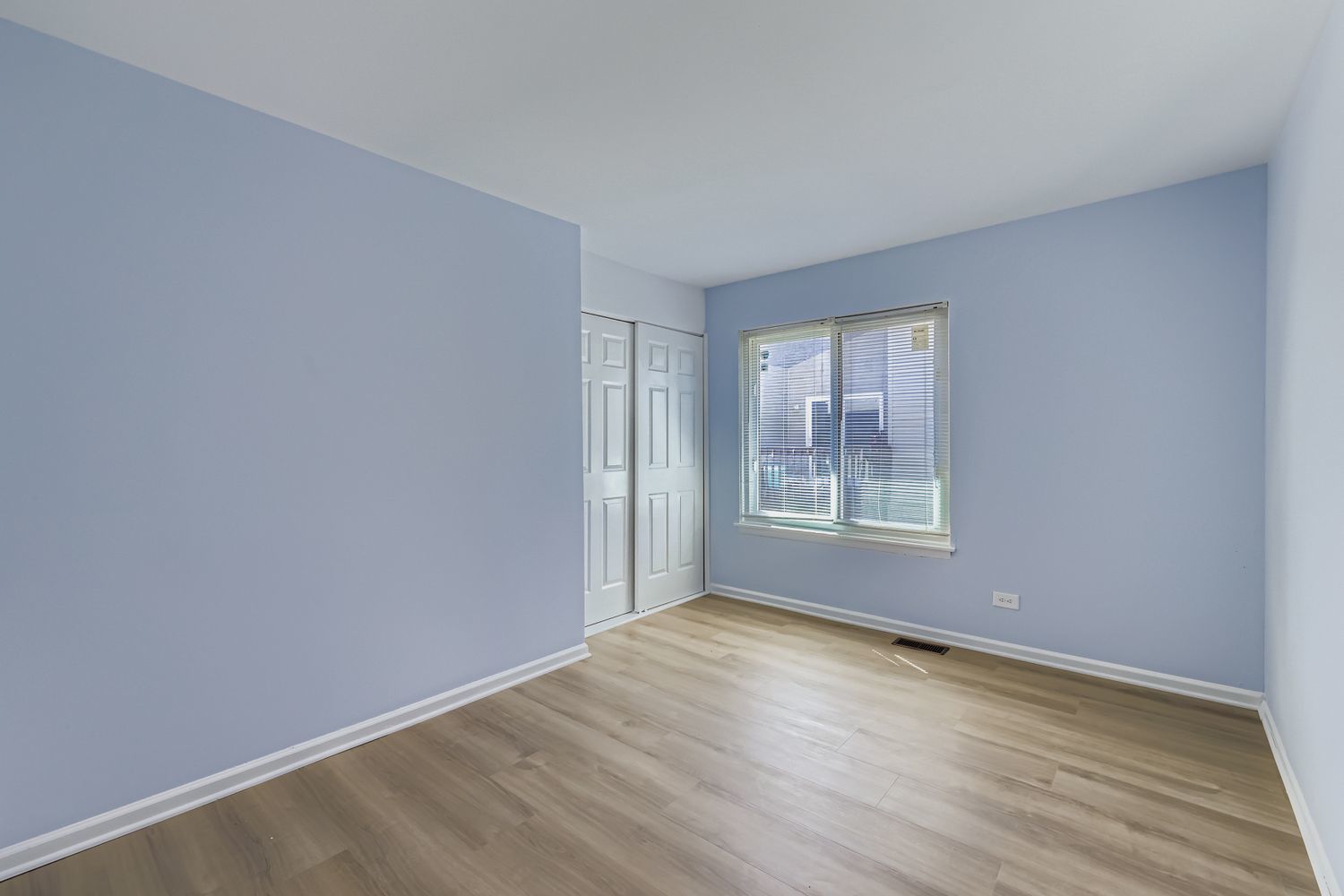 7526 Bristol Lane, Unit 2 Hanover Park, IL 60133 - Photo 16 of 21 a view of an empty room with wooden floor and a window