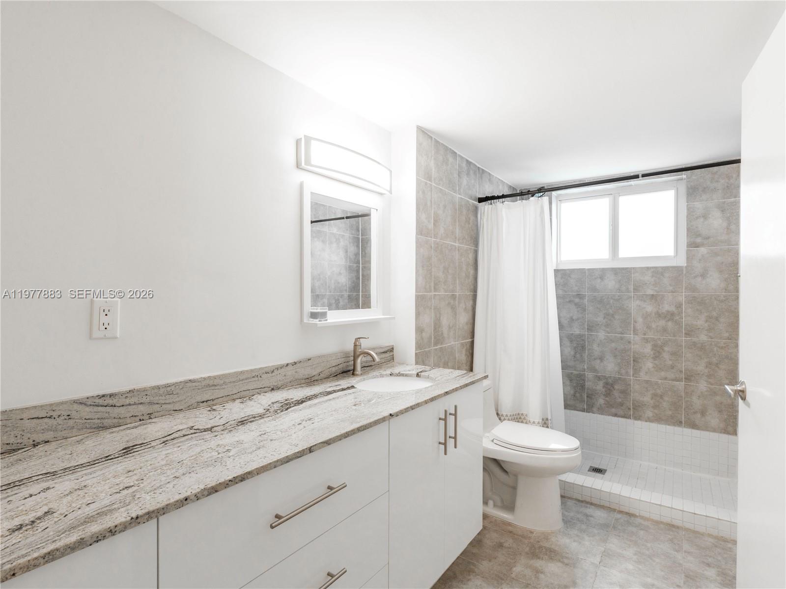 8329 Southwest 137th Avenue, Unit 8329 Miami, FL 33183 - Photo 16 of 33 a bathroom with a granite countertop sink a toilet and shower