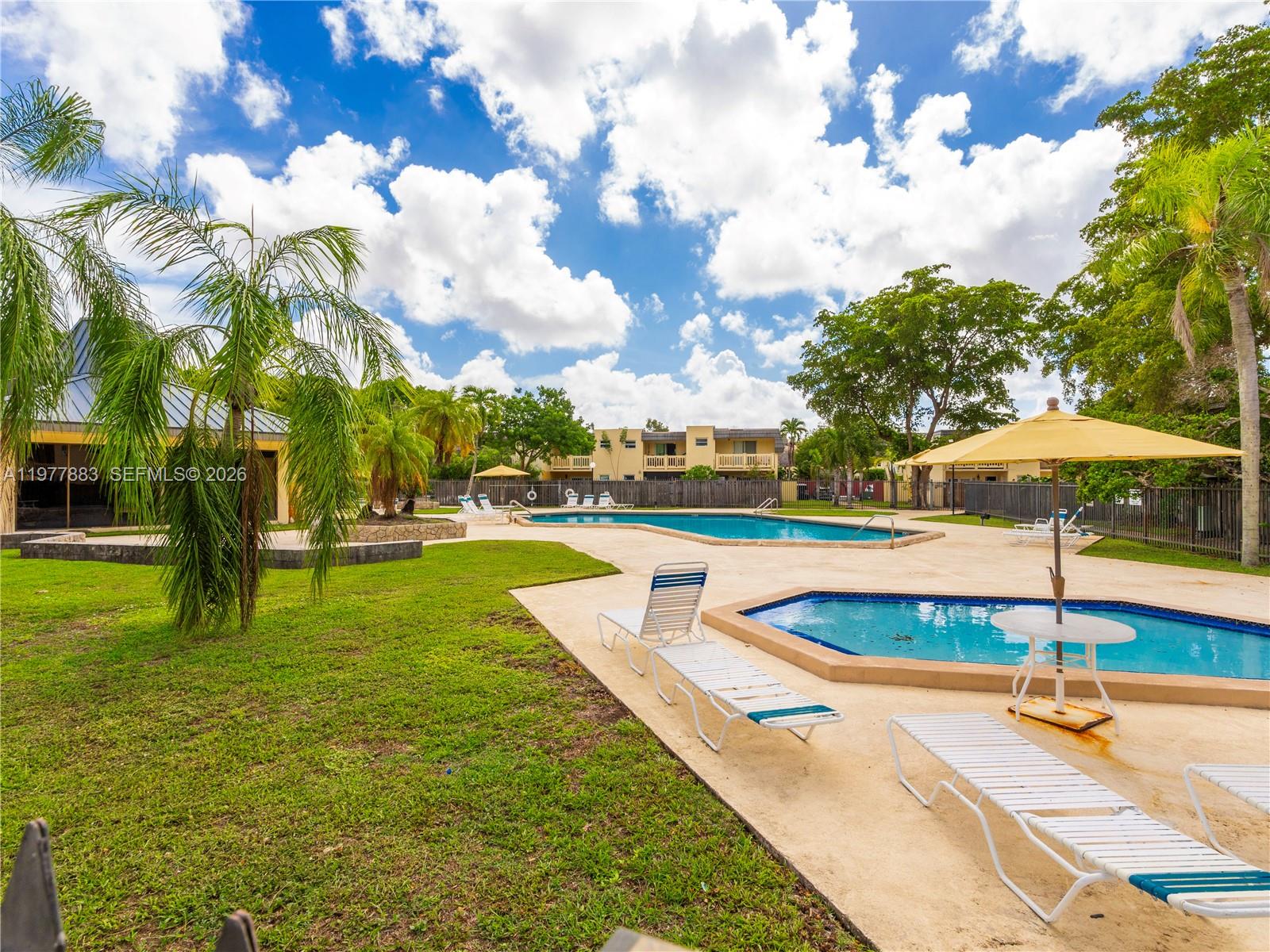 8329 Southwest 137th Avenue, Unit 8329 Miami, FL 33183 - Photo 31 of 33 a view of a swimming pool with an outdoor space and seating area