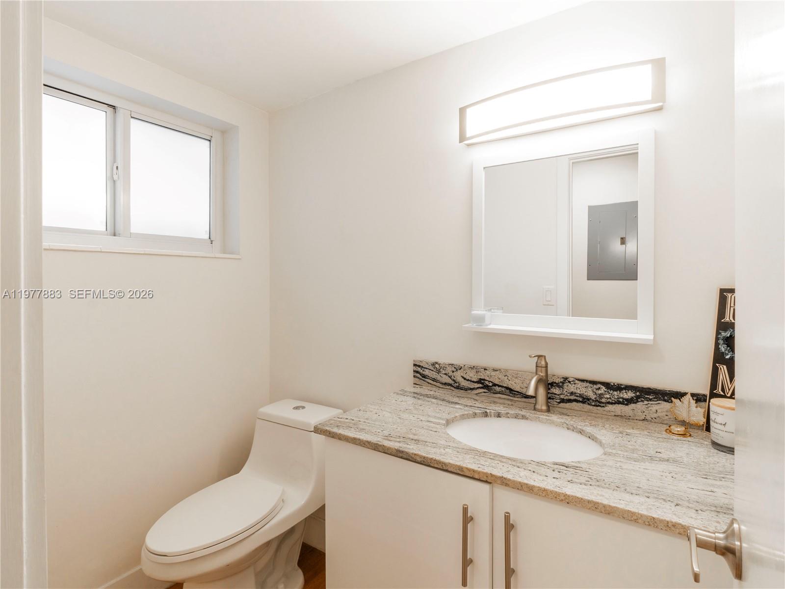 8329 Southwest 137th Avenue, Unit 8329 Miami, FL 33183 - Photo 6 of 33 a bathroom with a granite countertop toilet sink and mirror
