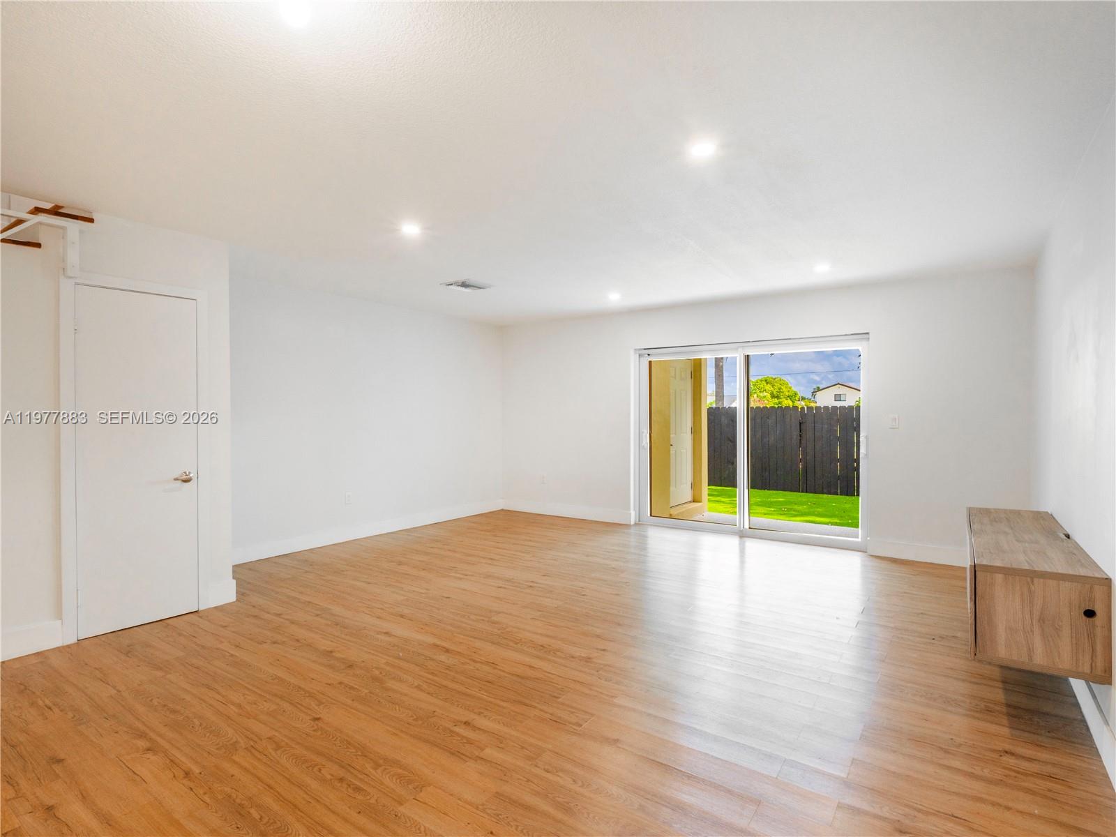8329 Southwest 137th Avenue, Unit 8329 Miami, FL 33183 - Photo 8 of 33 a view of an empty room with wooden floor and a window