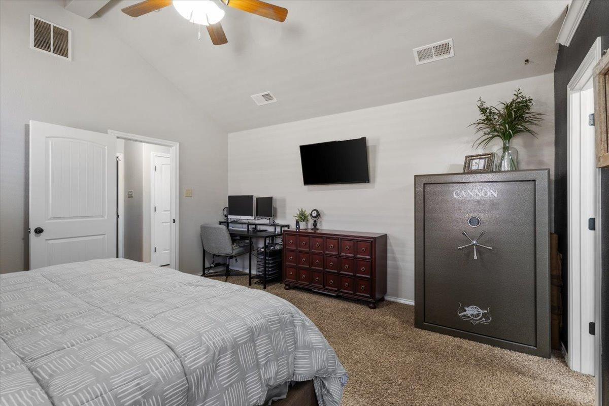 9804 Juneau Avenue Lubbock, TX 79424 - Photo 14 of 30 a bedroom with a bed and a flat screen tv