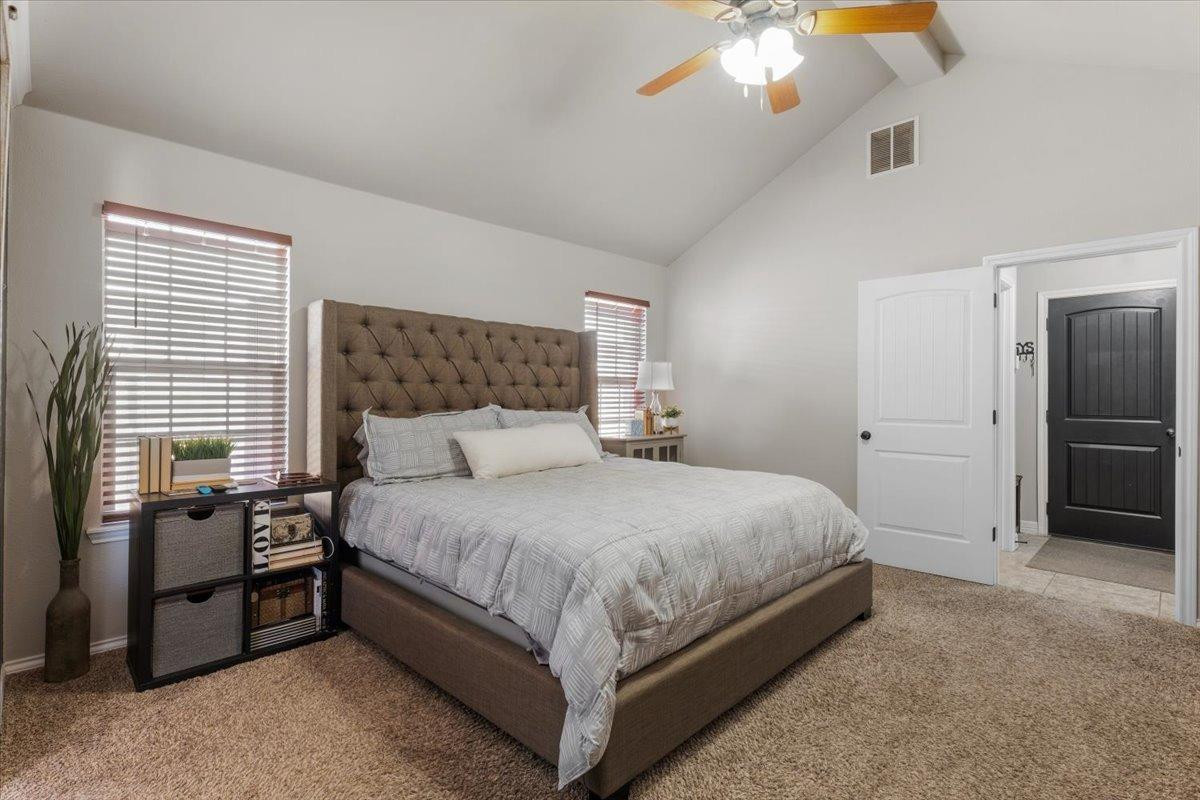 9804 Juneau Avenue Lubbock, TX 79424 - Photo 15 of 30 a large bed sitting in a bedroom and chandelier