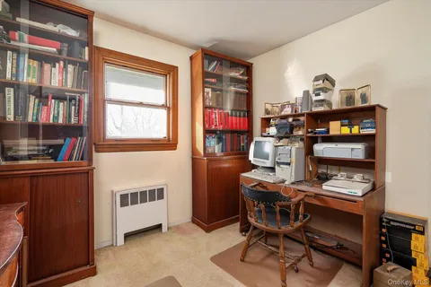 a view of a workspace with furniture and a window