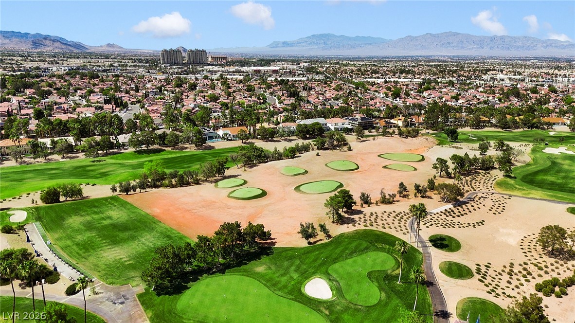 8981 Rivers Edge Drive Las Vegas, NV 89117 - Photo 64 of 69 An aerial perspective reveals a vast golf course bordered by a residential neighborhood and distant mountains.