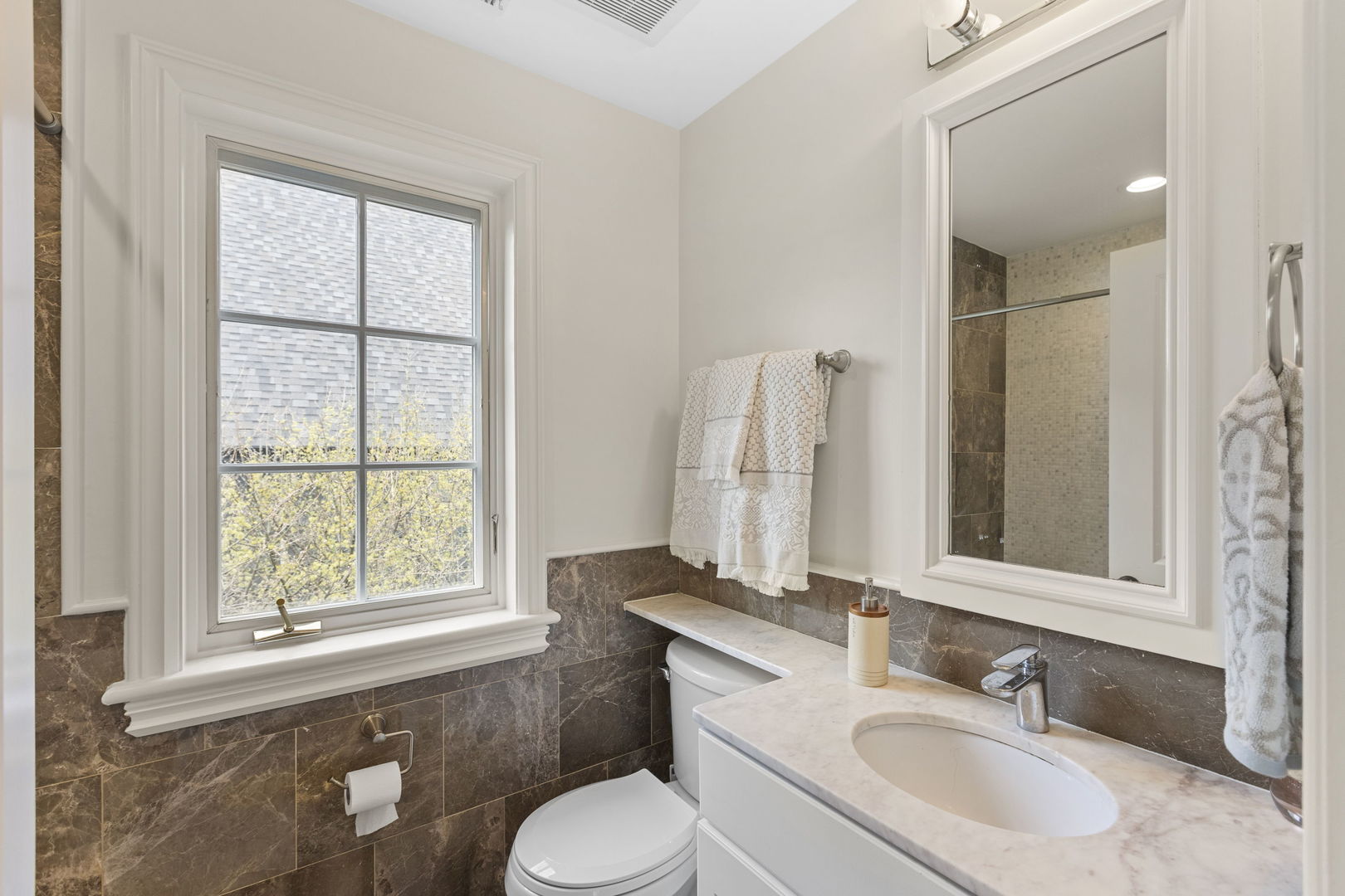 91 Wagner Road Northfield, IL 60093 - Photo 24 of 32 a bathroom with a granite countertop sink toilet and mirror
