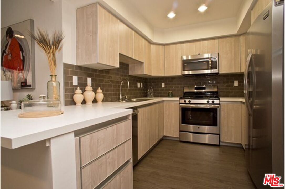 a kitchen with stainless steel appliances a sink a stove and a refrigerator
