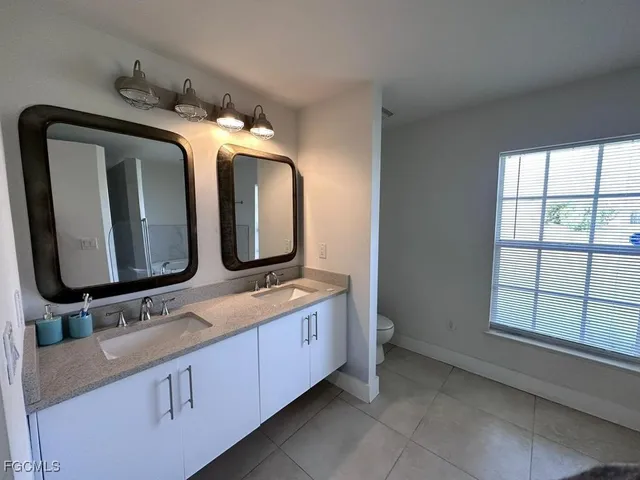 a bathroom with a double vanity sink and a mirror