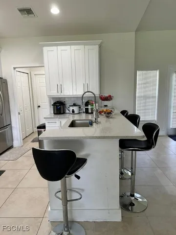 a view of kitchen with sink dining table and chairs