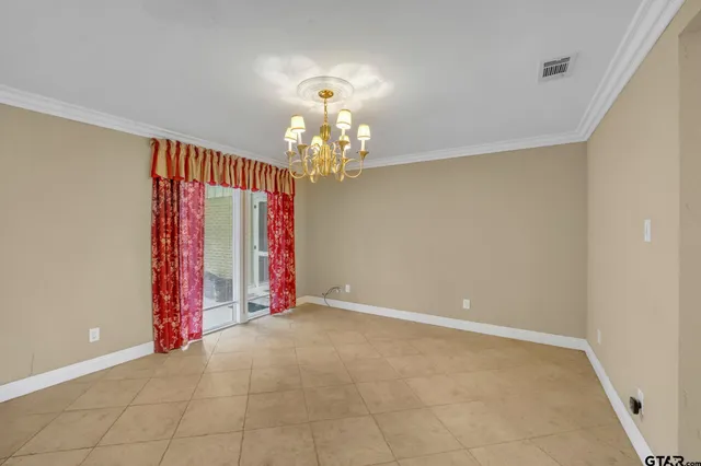 a view of a room with gym equipment and chandelier