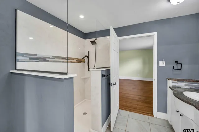 an empty room with windows and chandelier fan