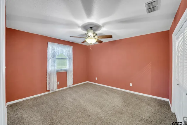 a view of a livingroom with wooden floor and a ceiling fan