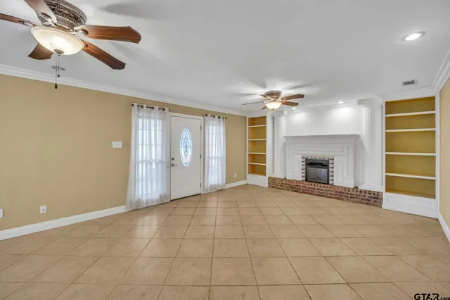 a view of an empty room with a ceiling fan and a window