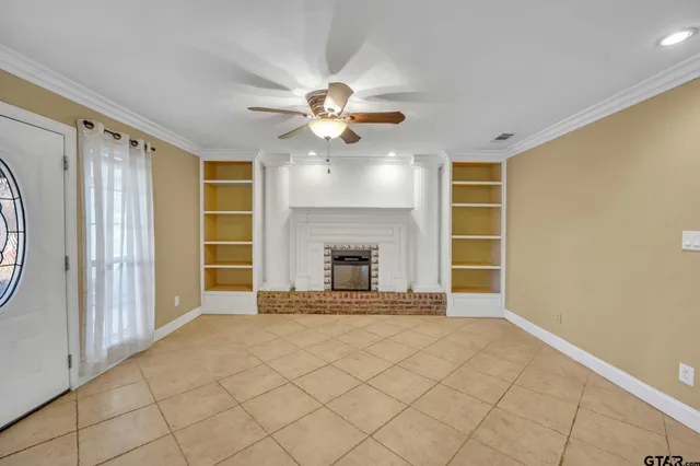 an empty room with windows and fireplace