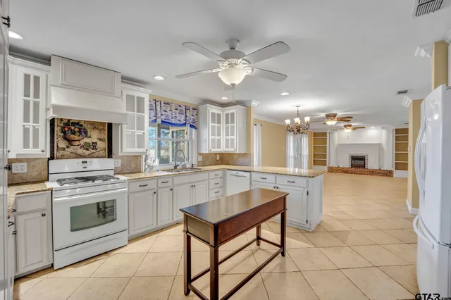 a kitchen with a stove a sink cabinets and wooden floor