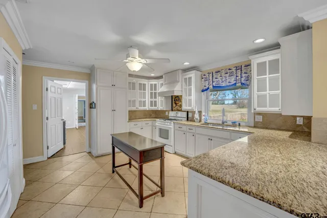 a kitchen with granite countertop sink cabinets and refrigerator