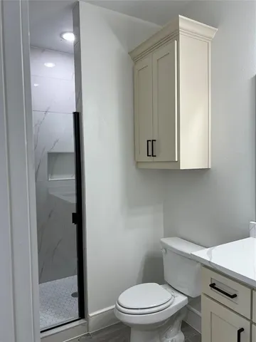 a bathroom with a toilet a sink and shower