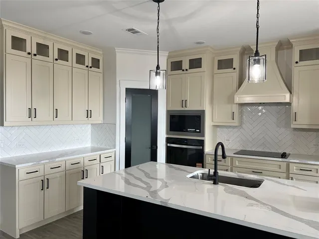a kitchen with kitchen island a sink stainless steel appliances and cabinets