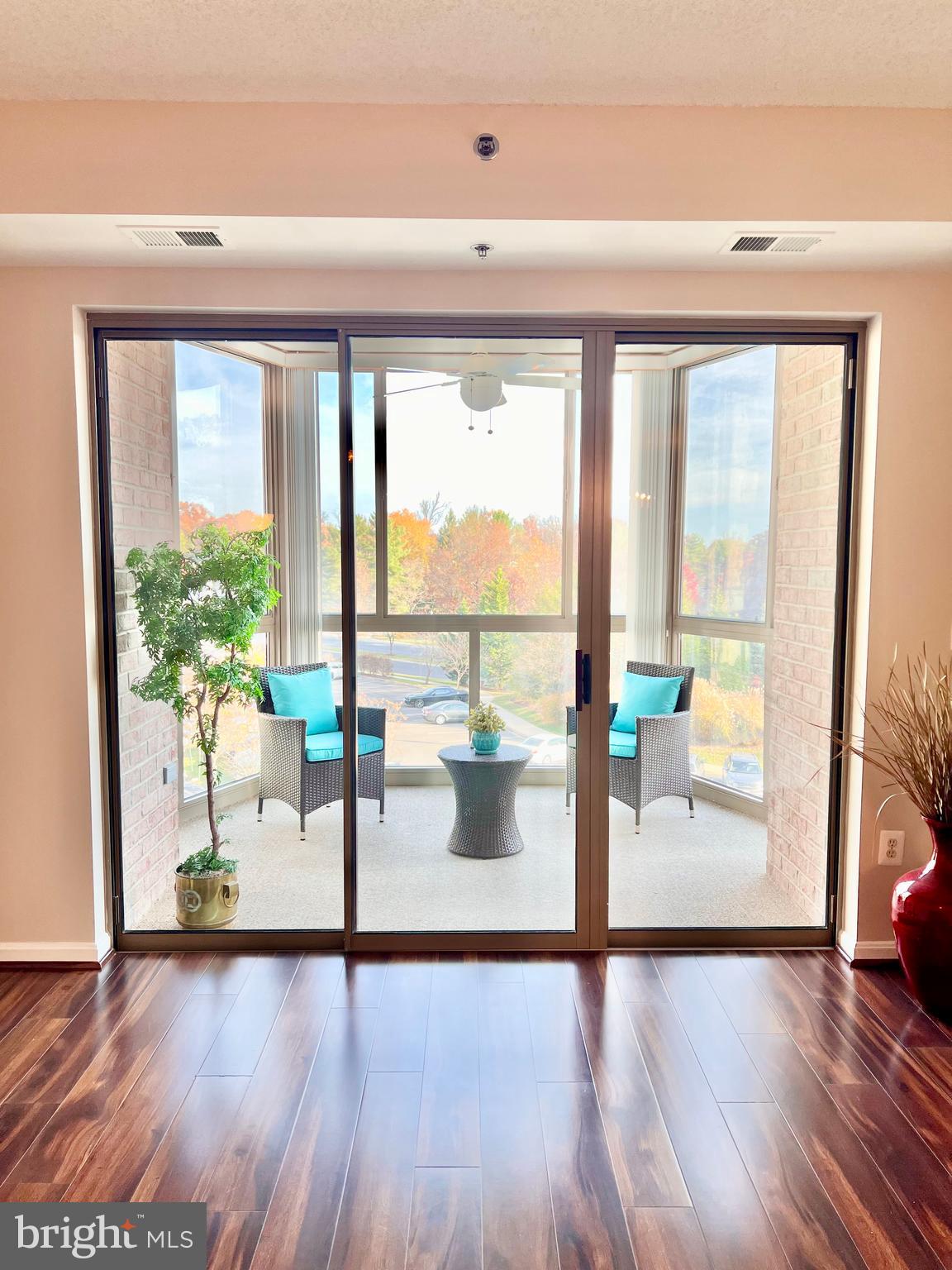 a view of a living room and floor to ceiling window hardwood floor