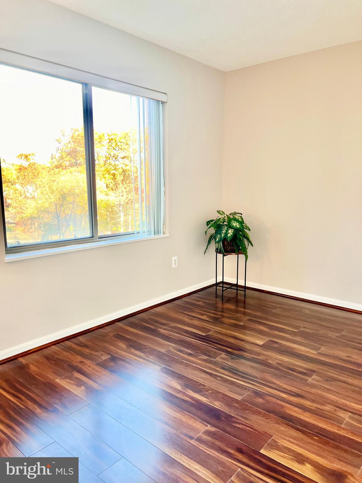 3200 North Leisure World Boulevard, Unit 314 Silver Spring, MD 20906 - Photo 11 of 42 a view of an empty room with wooden floor and a window