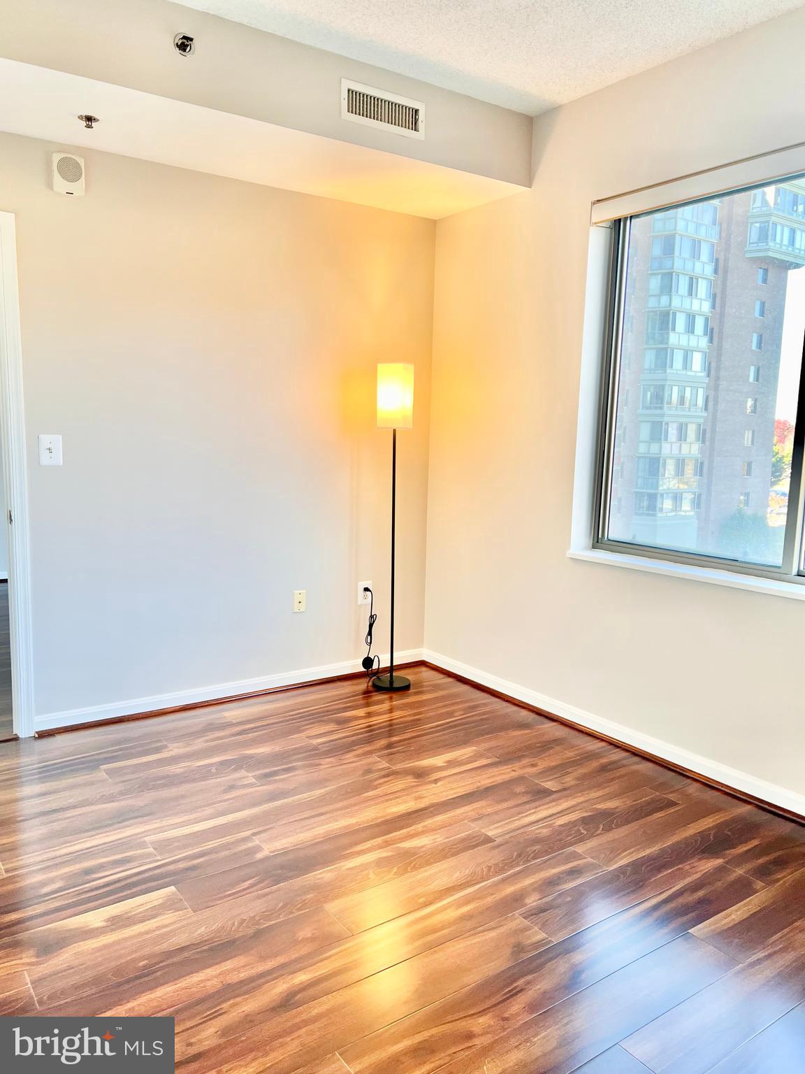 3200 North Leisure World Boulevard, Unit 314 Silver Spring, MD 20906 - Photo 12 of 42 a view of an empty room with wooden floor and a window