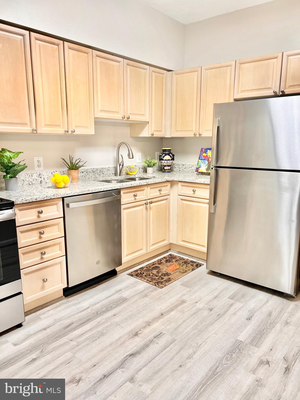 3200 North Leisure World Boulevard, Unit 314 Silver Spring, MD 20906 - Photo 2 of 42 a kitchen with a refrigerator a stove a sink and white cabinets with wooden floor