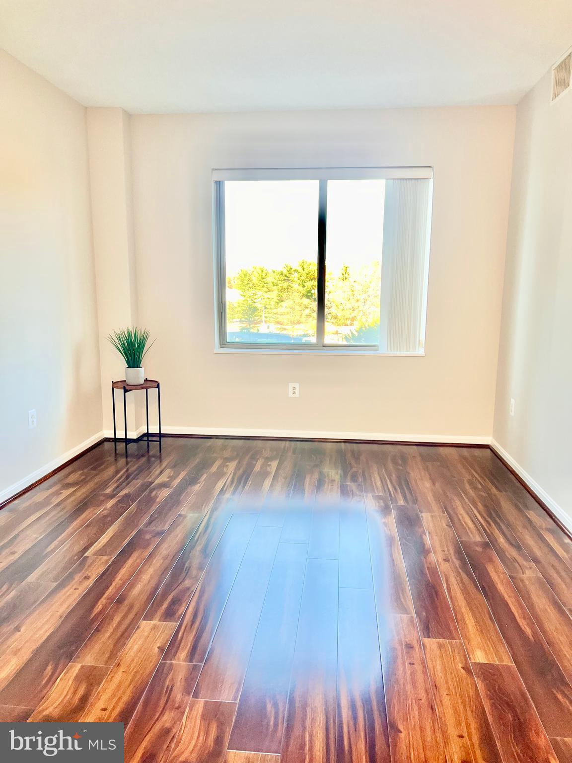 3200 North Leisure World Boulevard, Unit 314 Silver Spring, MD 20906 - Photo 6 of 42 a view of an empty room with window and wooden floor