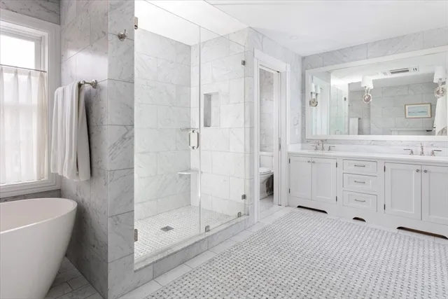 a bathroom with a bathtub shower sink and mirror