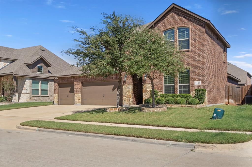 4125 Fern Loop Forney, TX 75126 - Photo 2 of 40 Brick and stone facade with arched windows, gabled roofline, and an attached two-car garage