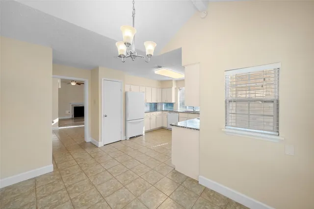 a large kitchen with white cabinets and white appliances