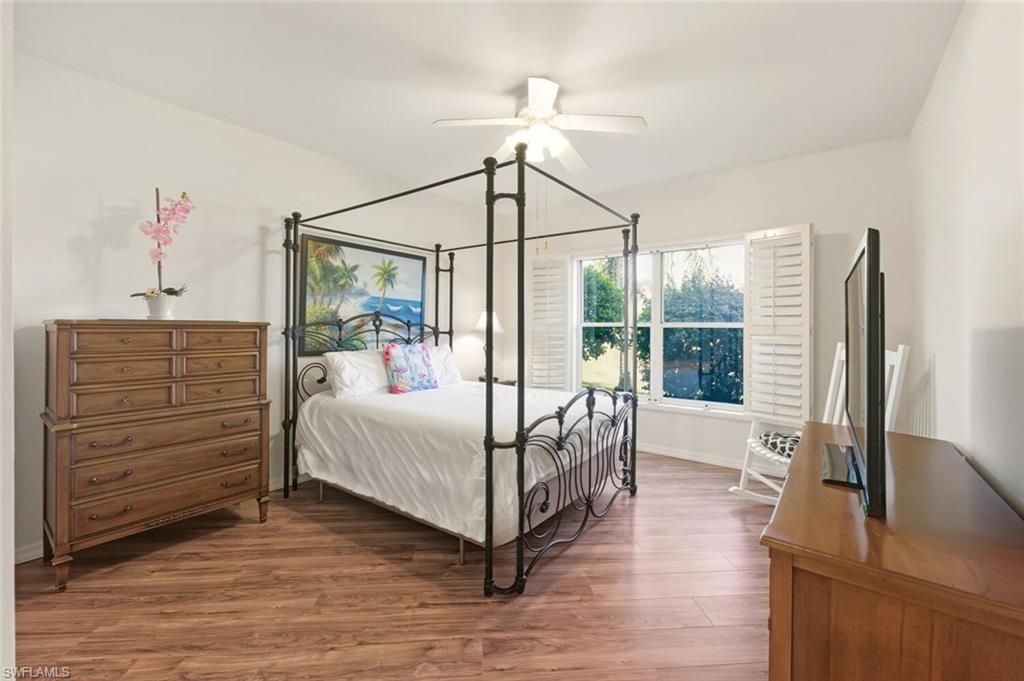 636 Windsor Square, Unit 102 Naples, FL 34104 - Photo 11 of 33 a bedroom with a bed and a mirror