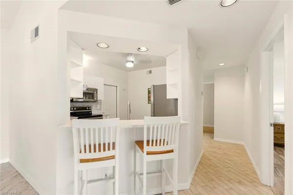 a hallway with stainless steel appliances a sink and a refrigerator